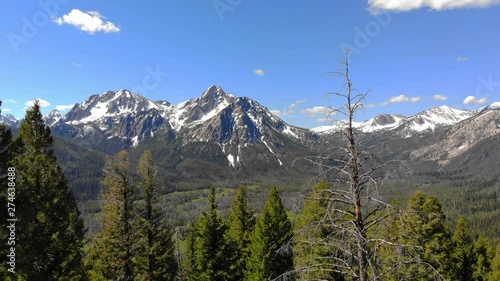 Fly through trees of a green Idaho forest towards McGown Peak in the Sawtooths photo