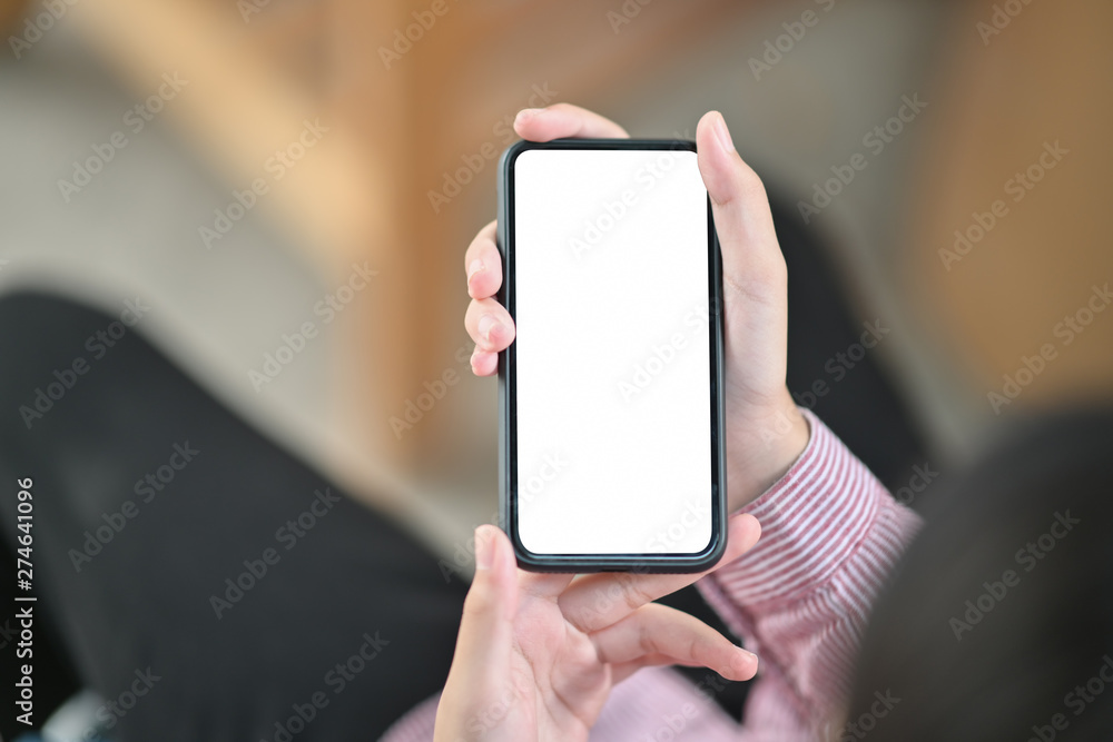 Image of hands holding black mock up mobile phone with blank screen
