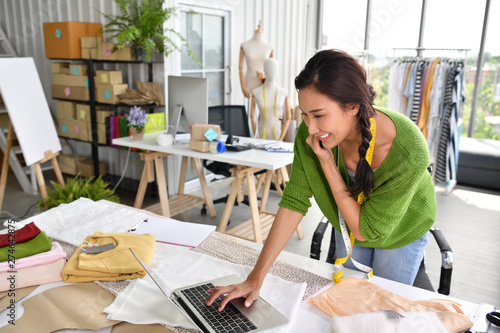 Young Asian woman entrepreneur / fashion designer working in studio photo