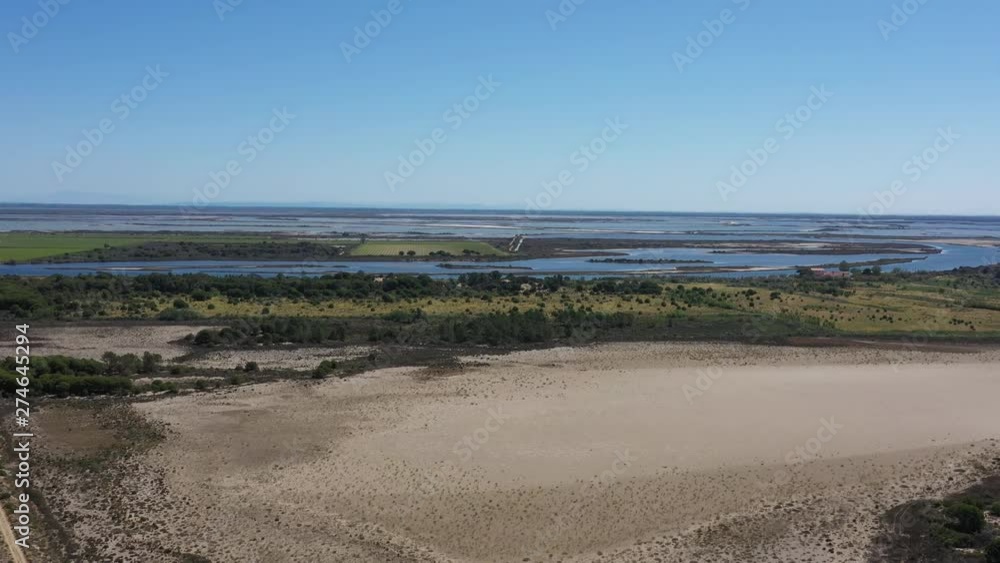 Sandy beach vineyards crops and salt evaporation pond aerial shot sunny day France Grau du Roi Sandy beach vineyards crops and salt evaporation pond aerial shot sunny day France Grau du Roi