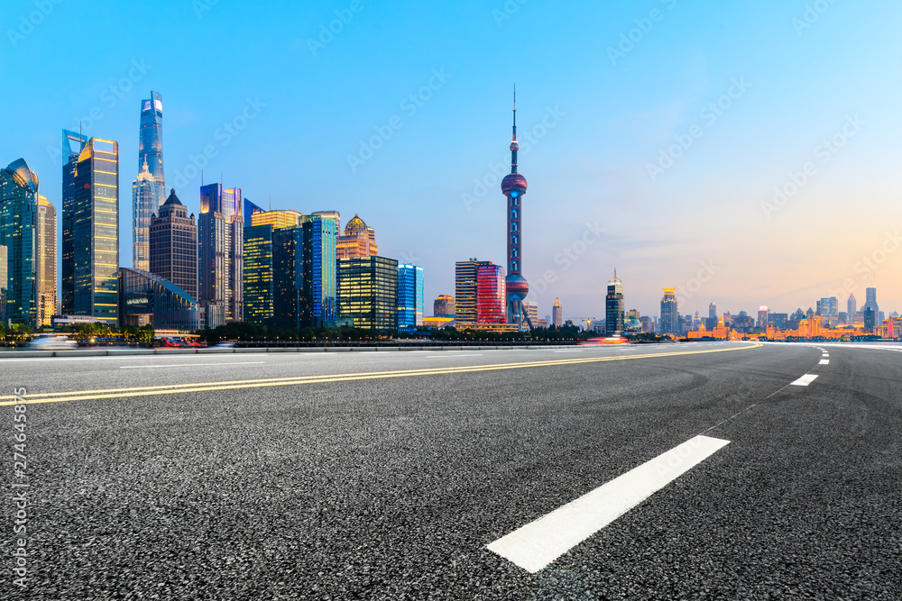 Shanghai modern commercial buildings and empty asphalt road at sunset,China