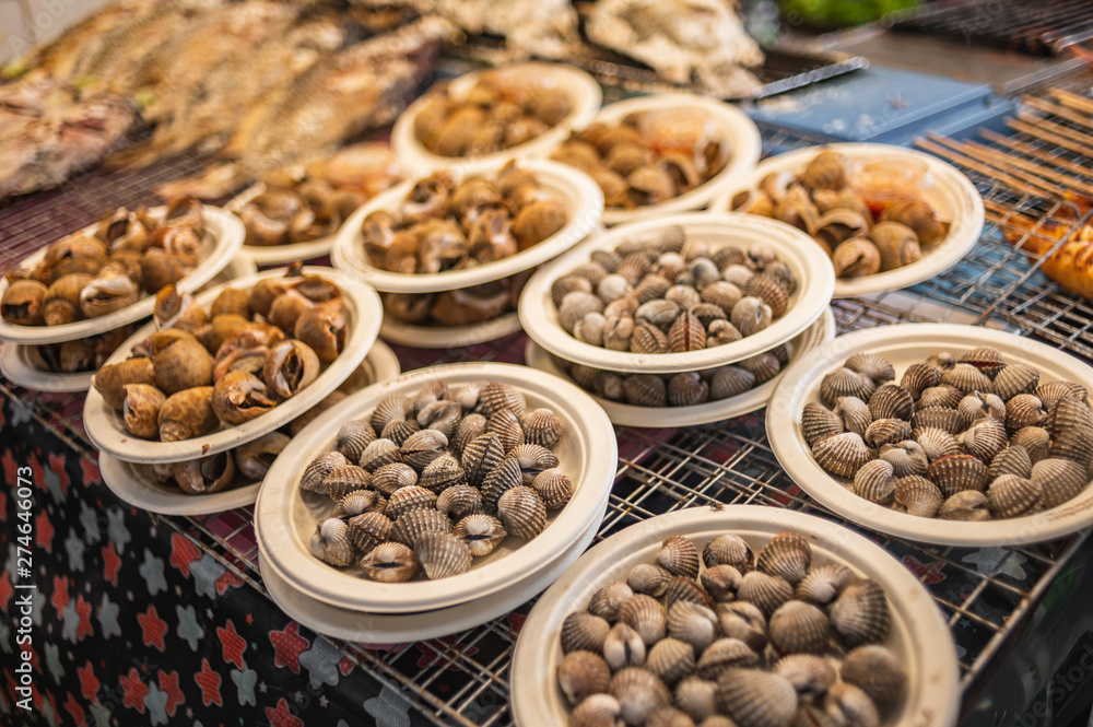 Street food in Bangkok, delicious looking cooked seashells and cockles on paper plate. Street food in Bangkok, delicious looking cooked seashells and cockles on paper plate.