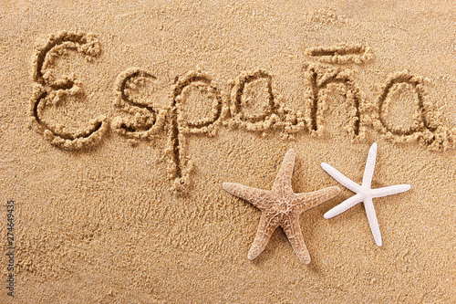 Espana word written in sand on a sunny spain spanish summer beach with starfish travel destination sign writing message photo