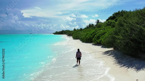 woman walking on paradise white sand beach on caribbean tropical island with preserved nature. Palm forest and turquoise water photo