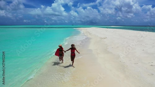 two attractive young women running on sandbar of Mansalangan in Balabac, aerial shot in Palawan, Philippines, friendship or homosexual relationship photo