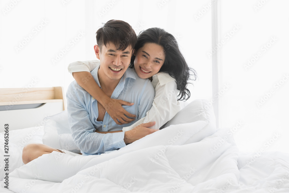 Couple sits on bed, they hug each other by love.. Couple sits on bed, they hug each other by love..