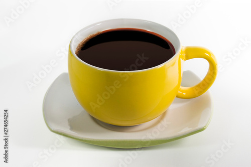 Yellow cups with saucer filled with black coffee liquid Isolated white background