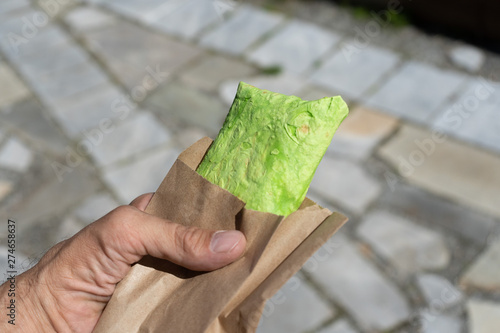 Green pita bread, shaurma, shaverma, kebab, doner. Shawarma in male hand closeup.