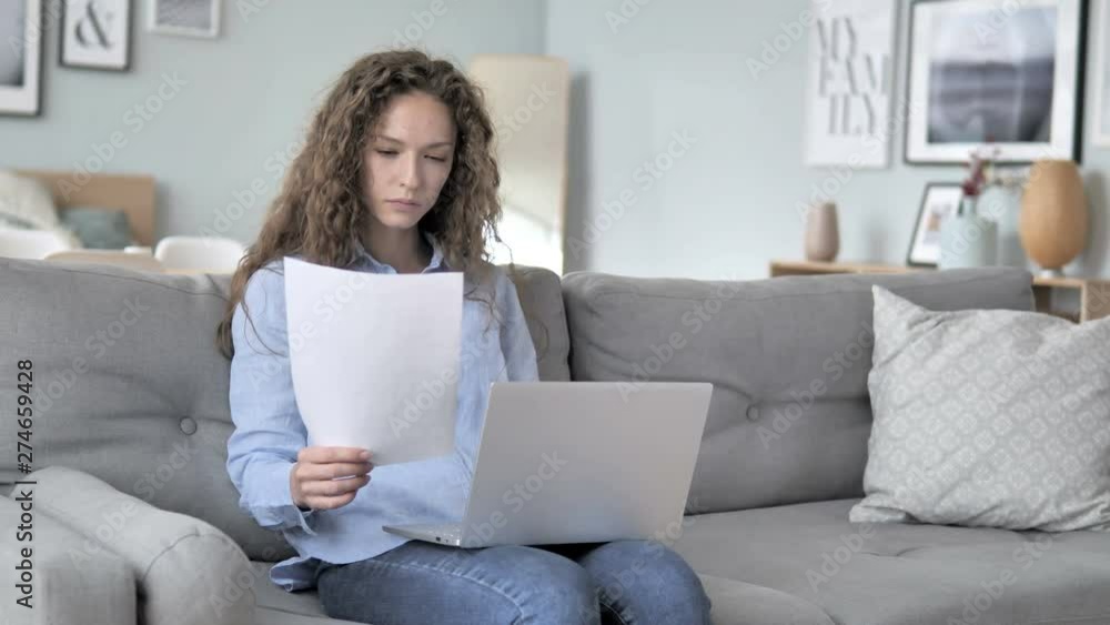 Curly Hair Woman Doing Paperwork while Sitting on Couch Curly Hair Woman Doing Paperwork while Sitting on Couch