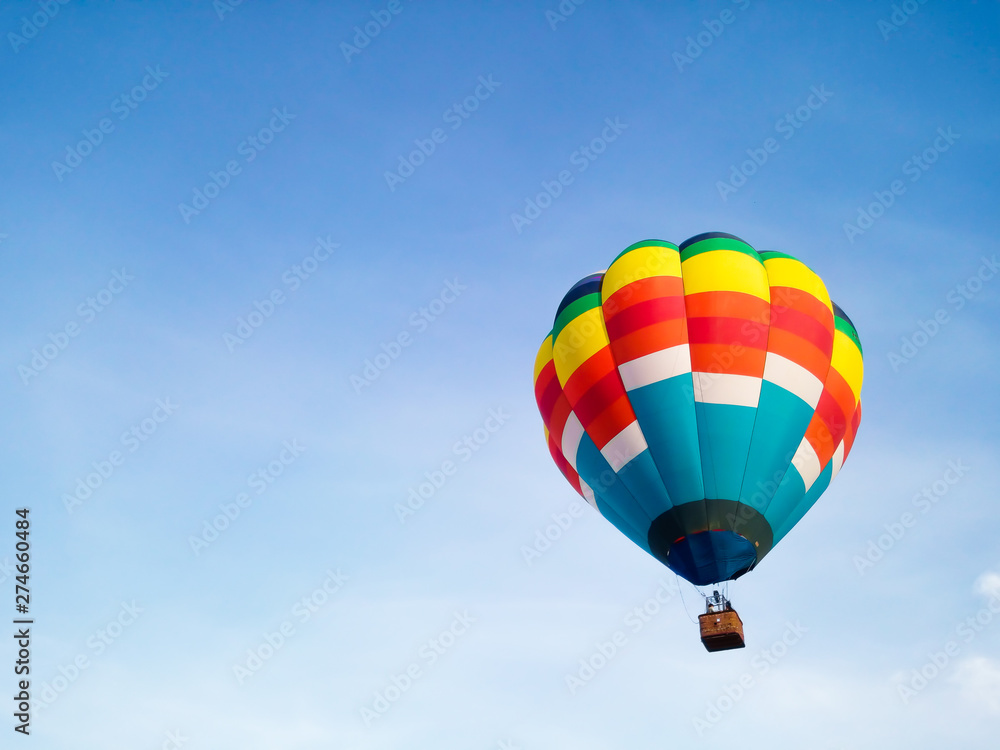 Fototapeta premium Hot air balloon in Flight with blue sky background