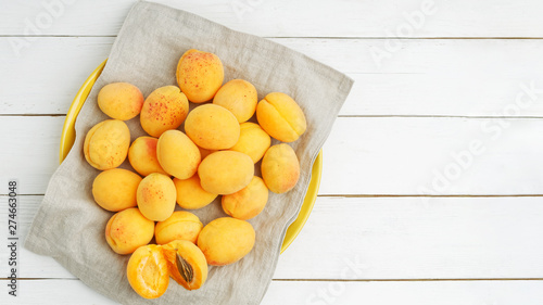 Heap of ripe apricot fruits on a cloth napkin. Top view. Copyspace.