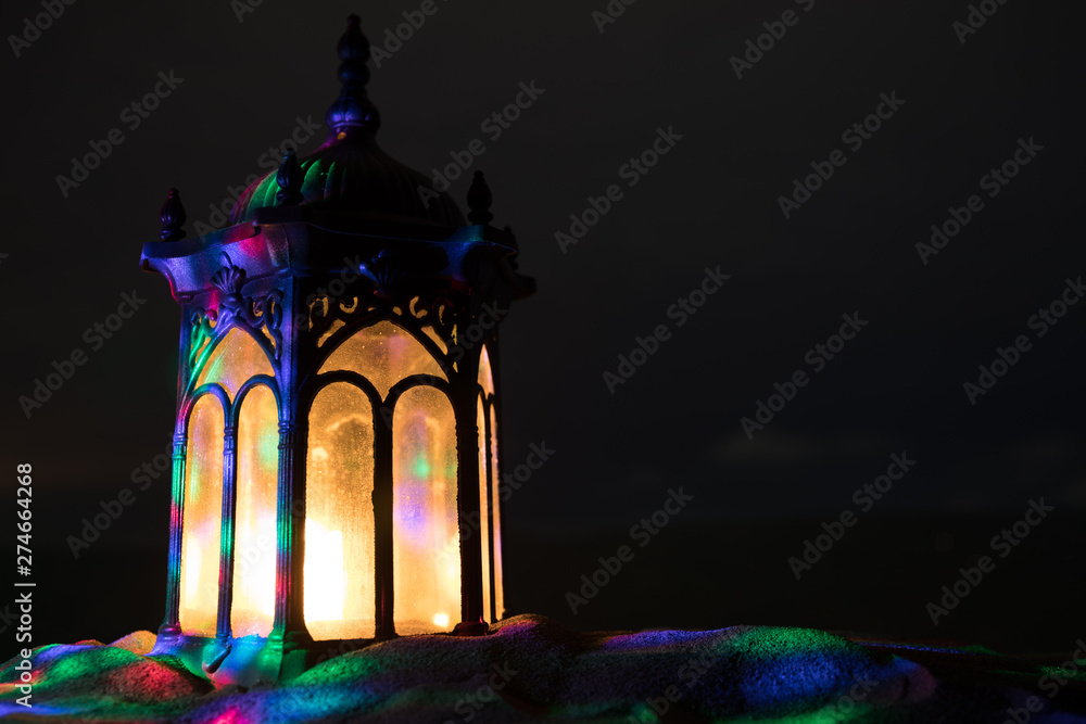Fototapeta Ornamental Arabic lantern with burning candle glowing at night. Festive greeting card, invitation for Muslim holy month Ramadan Kareem.