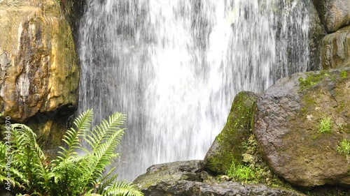 A close up view of cascading water falling over the rocks at Longshan Buddhist temple in Taipei city, Taiwan  photo