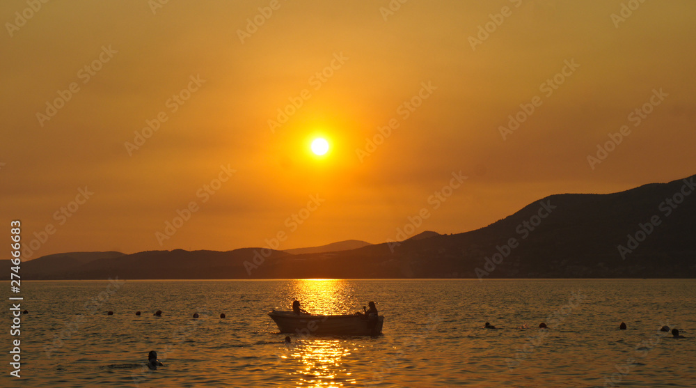 Sunset with a boat on the water on Ciovo island in Croatia near Trogir city, Dalmatia
