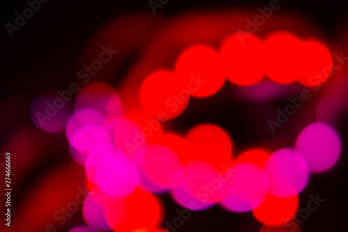 Duotone Red and purple abstraction of blurry neon lights on black