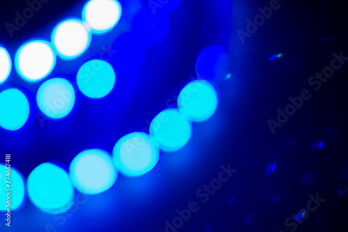 Blue neon blurry lights and reflections. Festive winter background of 80s colors photo