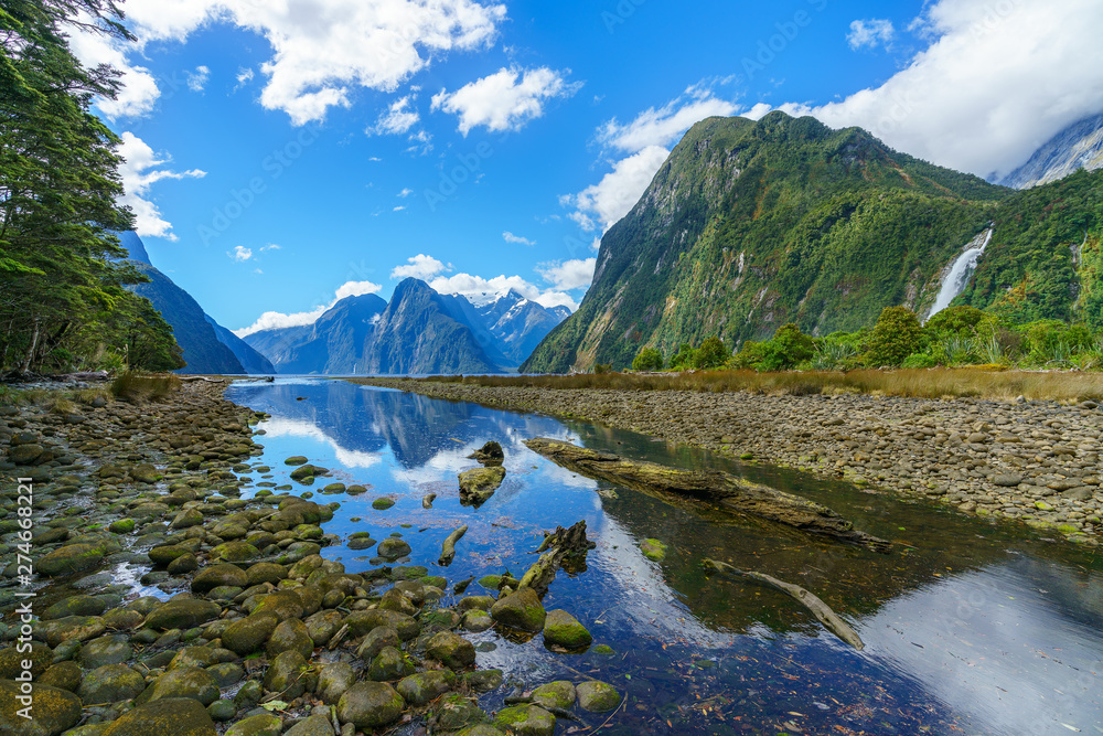 reflections of mountains and a waterfall, milford sound, new zealand 1