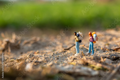 Miniature people : Traveler miniature with backpack stand and walking on meadow, Travel and Adventure concepts. 