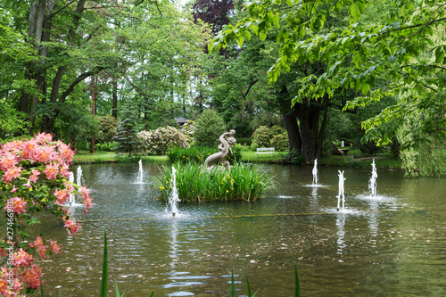 Fountain and sculpture in city park in summer