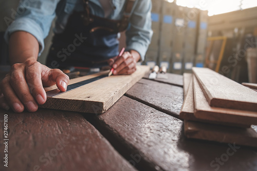 Carpenter working with equipment on wooden table in carpentry shop. woman works in a carpentry shop.