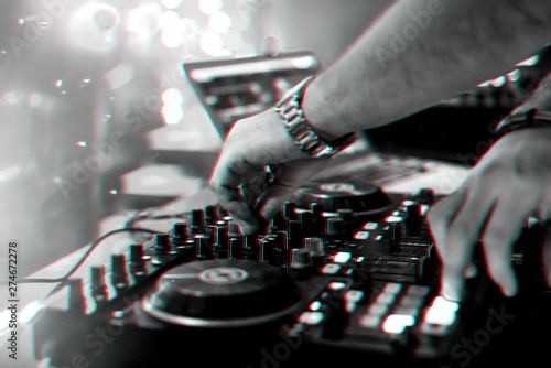 hands DJ mixing and playing music on a professional controller mixer