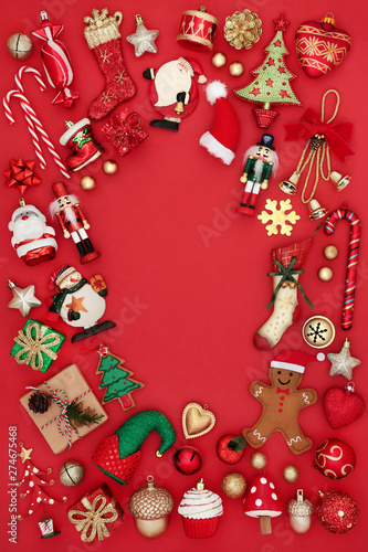 Christmas background border with a large collection of tree bauble decorations and symbols on red background with copy space.