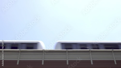 Low angle view as a city passenger train passes left to right on an elevated track system.with copy space for text 