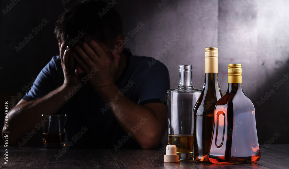 Bottles with alcoholic beverages and the figure of a drunk man Bottles with alcoholic beverages and the figure of a drunk man