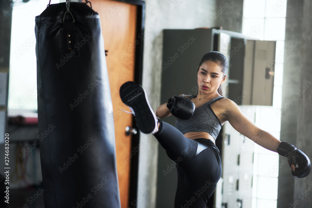 Woman training Thai boxing in gym