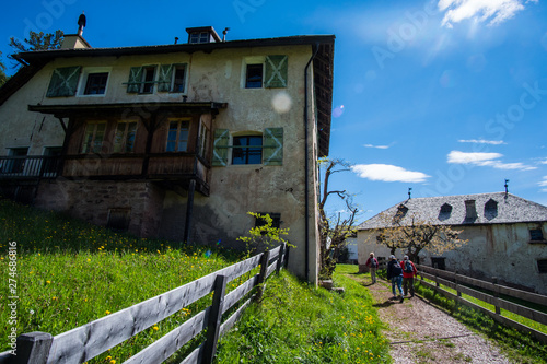 Wandergruppe geht an altem Ansitz in Südtirol vorbei photo