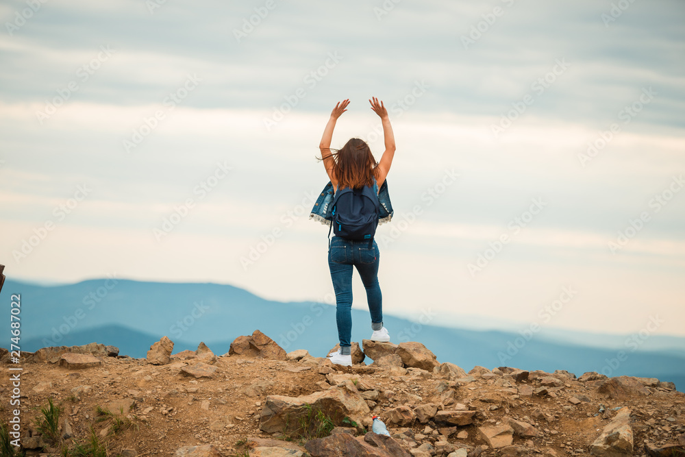 A healthy woman celebrates during a beautiful sunset. Happy and free. stand on the edge of the mountain. beautiful mountain. A healthy woman celebrates during a beautiful sunset. Happy and free. stand on the edge of the mountain. beautiful mountain.