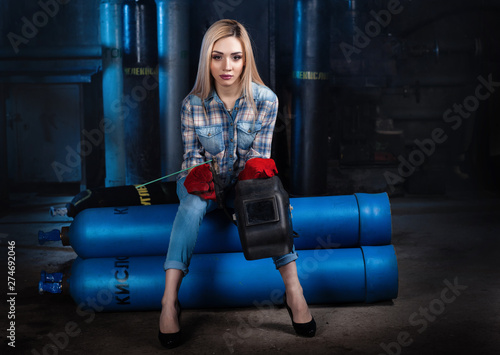 Girl with a welding machine. girl in a blue shirt photo