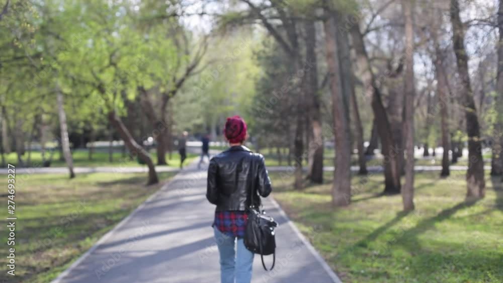 beautiful young stylish woman walks in the park with a cup of coffee. modern girl in a leather jacket, a shirt in a cage, with a bandage on his head. stylish brunette with glasses walks in the spring beautiful young stylish woman walks in the park with a cup of coffee. modern girl in a leather jacket, a shirt in a cage, with a bandage on his head. stylish brunette with glasses walks in the spring