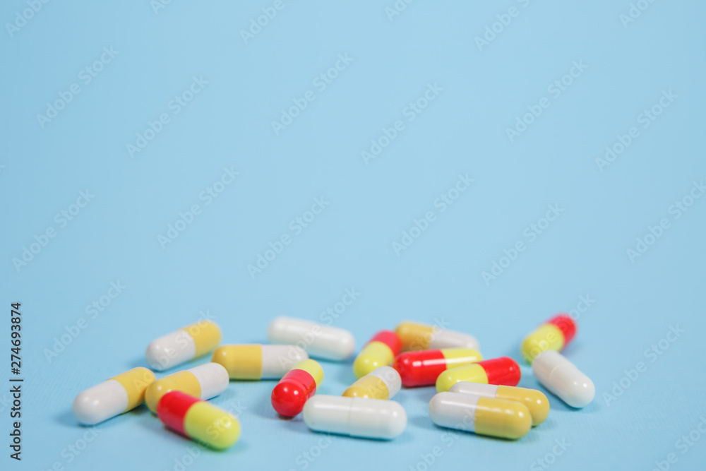Pills are scattered over a blue background Pills are scattered over a blue background