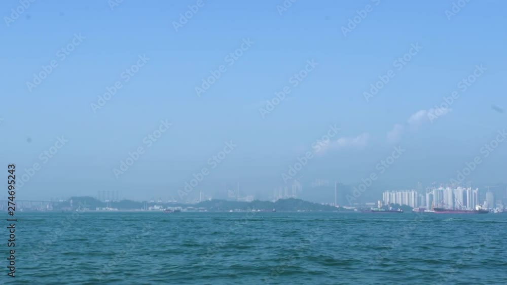 Panoramic view city buildings and business skyscrapers on highlands Hong Kong, China. Sea view and ships floating on horizon. Industrial port and shipyard. Urban architecture asian city. Panoramic view city buildings and business skyscrapers on highlands Hong Kong, China. Sea view and ships floating on horizon. Industrial port and shipyard. Urban architecture asian city.