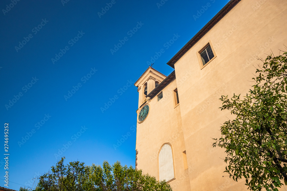 Fototapeta premium The Convent of S. Maria delle Grazie, in Santa Maria square. The bell tower with the clock. The blue sky at sunset. Zagarolo, Province of Rome, Lazio, Italy