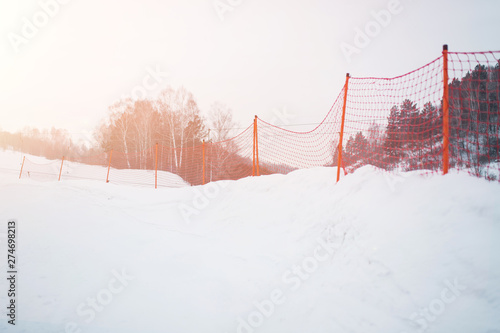 Mesh fence. The net is covered with snow, ice crystals. Close-up grids are covered with a thick layer of white crystalline frost. ski resort. Red grid photo