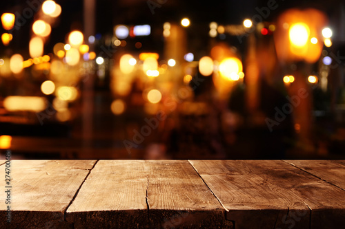 background of wooden table in front of abstract blurred restaurant lights