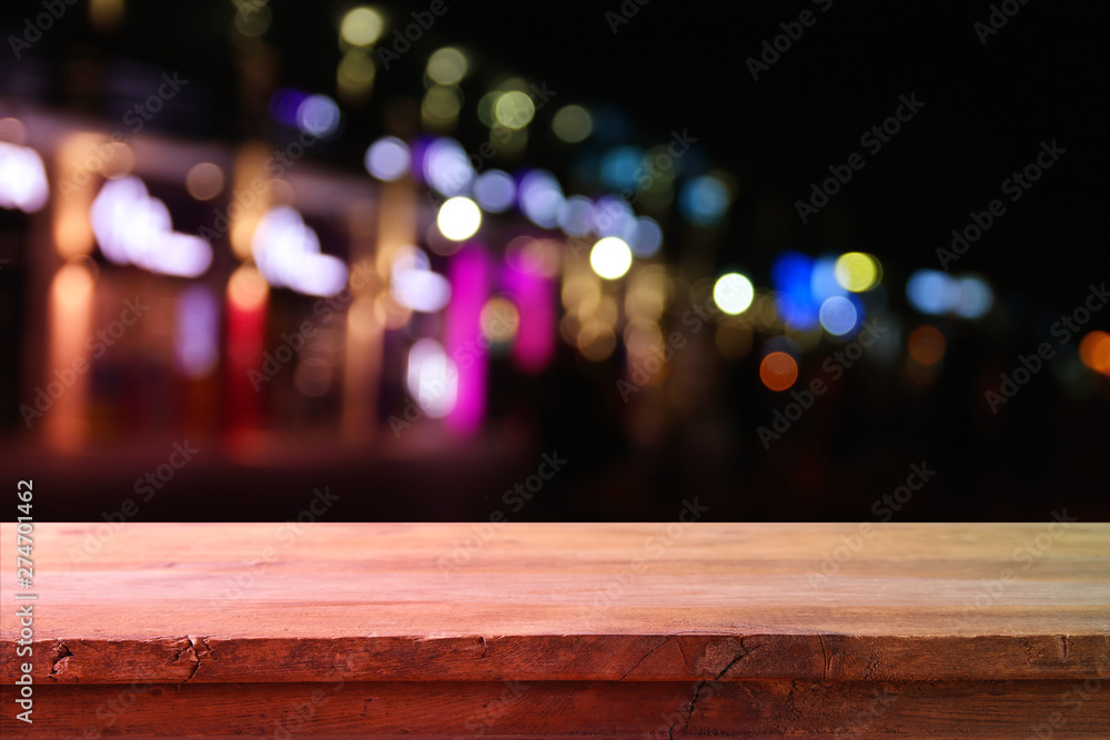 background of wooden table in front of abstract blurred restaurant lights