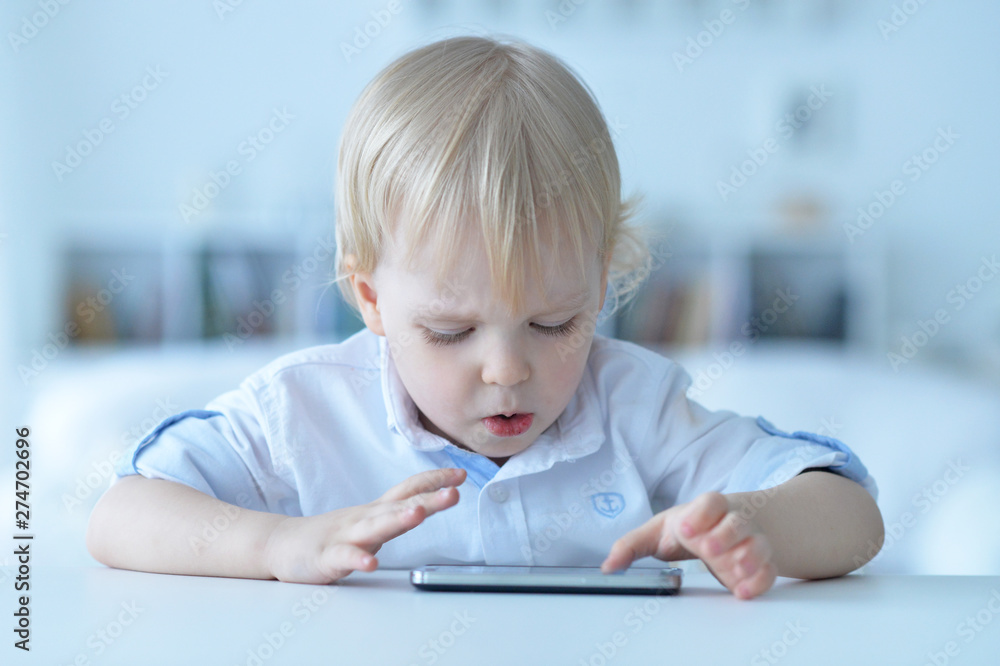 Portrait of boy with smartphone playing the game at home Portrait of boy with smartphone playing the game at home