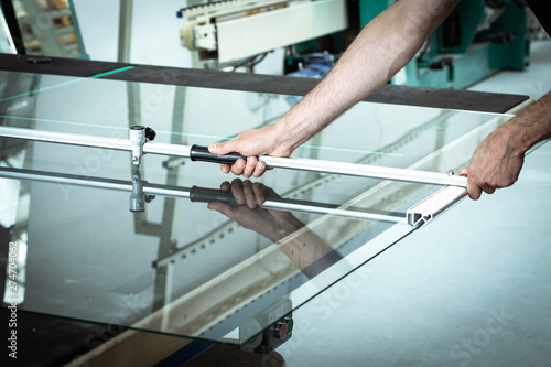 A worker cuts glass in a glass workshop