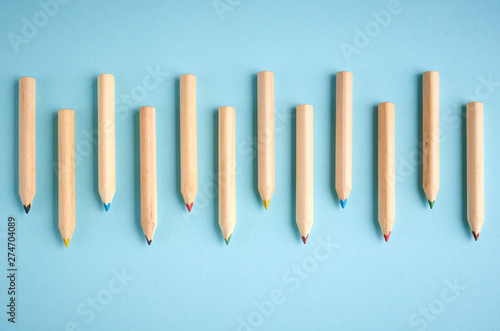 Wooden color pencils on blue background  flat lay