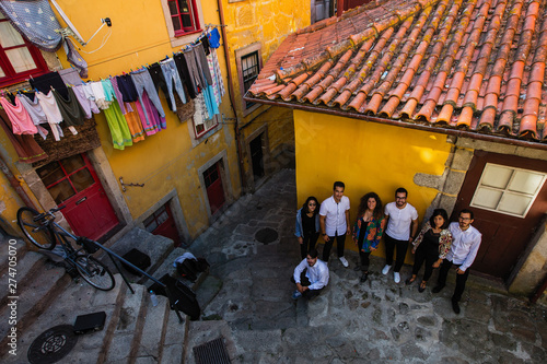 Company of young people on a narrow street of the old city. Porto^ Portugal.