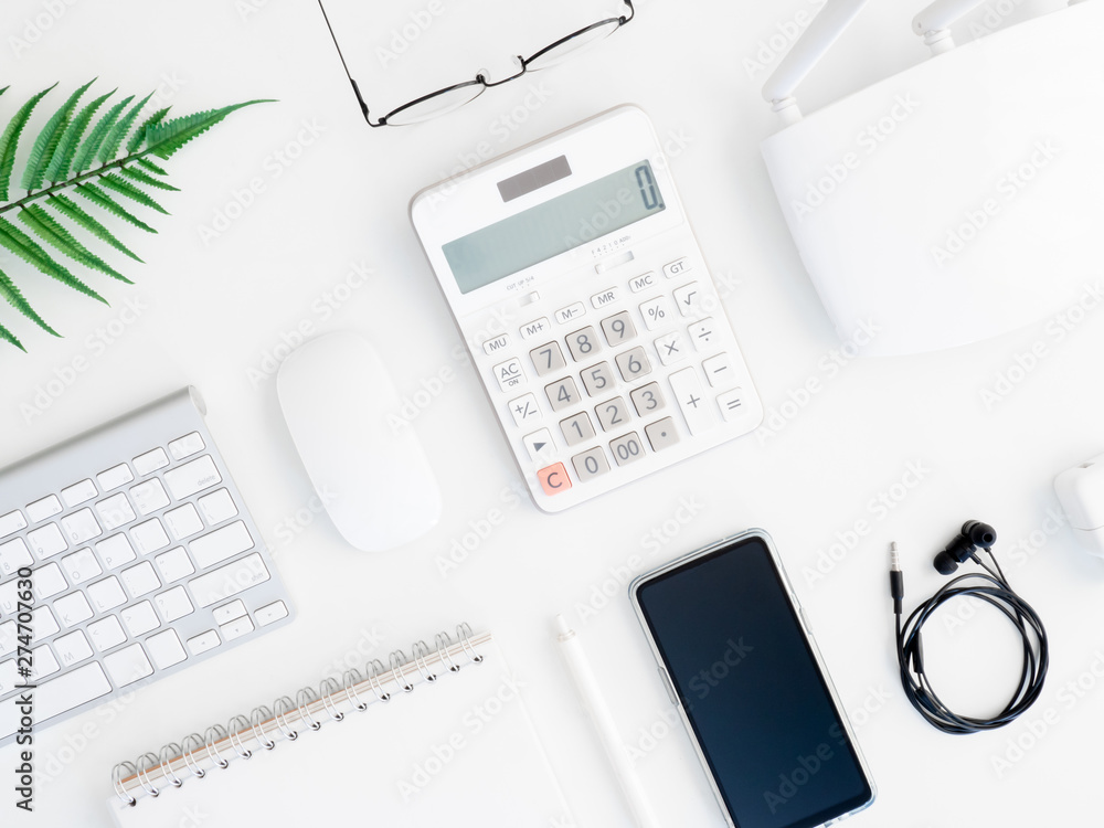 top view of office desk table with calculator, notebook, plastic plant, smartphone and keyboard on white background, graphic designer, Creative Designer concept. top view of office desk table with calculator, notebook, plastic plant, smartphone and keyboard on white background, graphic designer, Creative Designer concept.