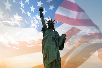 Double exposure with statue of liberty and United States flag blowing in the wind.