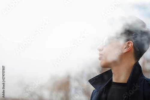Asian young man smoking on the street