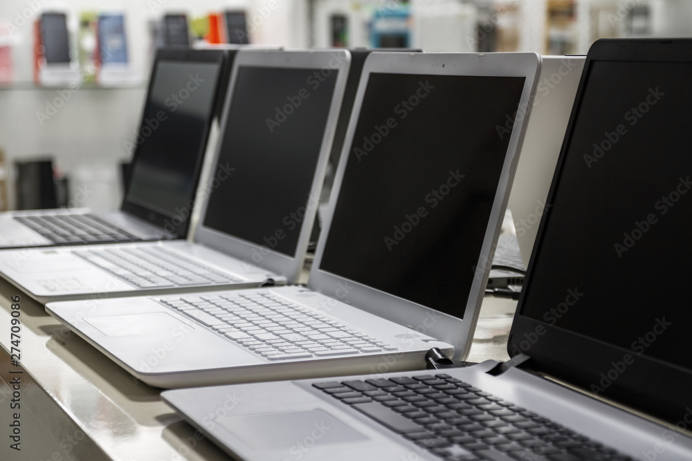 © marketlan - A row of laptops in computer shop. Closeup, selective focus © marketlan - A row of laptops in computer shop. Closeup, selective focus