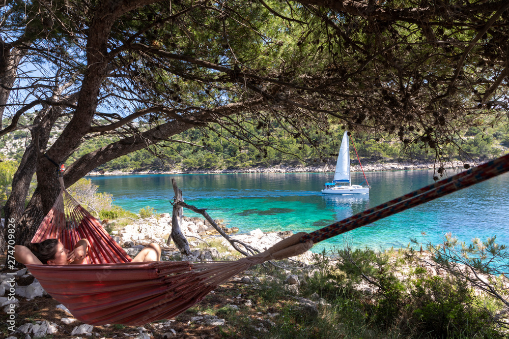 Woman relaxing in the hammock on a hot sunny day on the island lastovo, croatia
