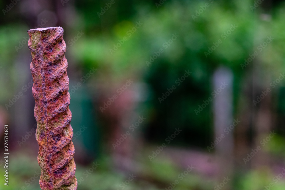 Close up of red rusty and stripped metal round on green blurry background Close up of red rusty and stripped metal round on green blurry background
