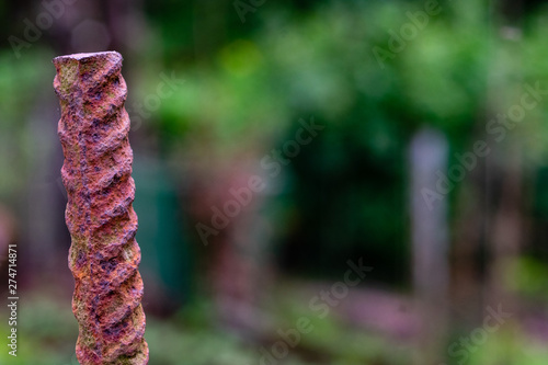 Close up of red rusty and stripped metal round on green blurry background